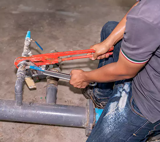 Licensed plumber repairing a copper pipe leak in a Texas basement